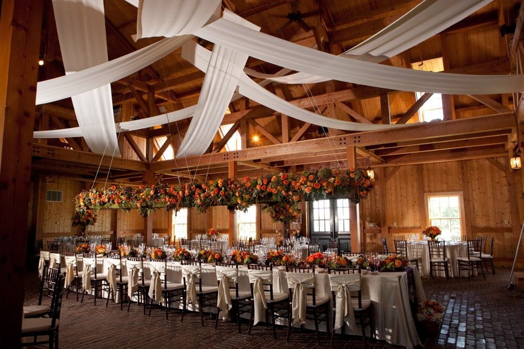Elegant Farm Wedding at Milldale elegant barn wedding dining table with orange flowers