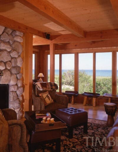 Cape Cod, MA (4647) den with stone fireplace and windows overlooking the water